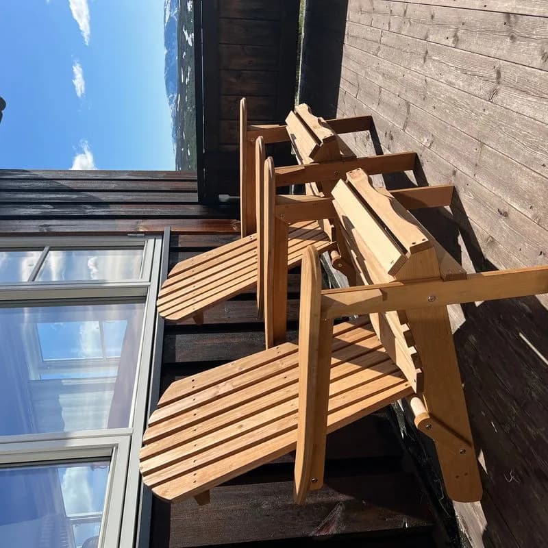 Adirondack stol ved hyttevegg i blomsterhagen